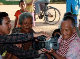 Filmmaker Nou Va showing villagers how to use the camera. Photo: Leah Roth Howe.